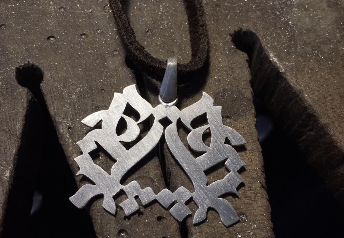 A handmade silver typographic necklace — a student result from the Silversmithing class